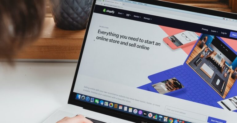 person using macbook pro on white table