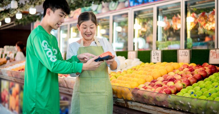a man and a woman standing in front of a fruit stand
