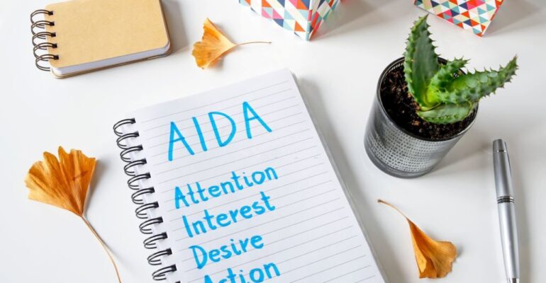 AIDA Attention Interest Desire Action written in a notebook on white table