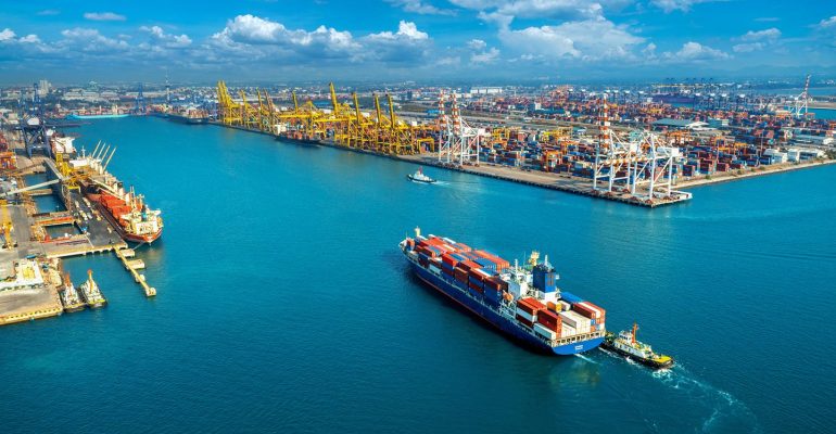 Aerial view of cargo ship and cargo container in harbor.